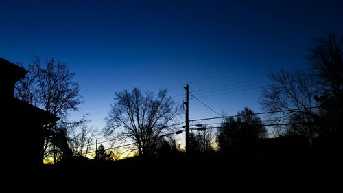 Low angle view of silhouette bare trees against sky