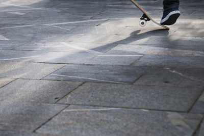 Low section of person skateboarding on footpath