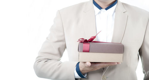 Midsection of man holding mobile phone in box