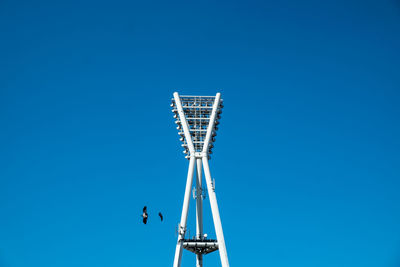 Low angle view of floodlight against clear blue sky