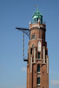 Low angle view of bell tower against blue sky