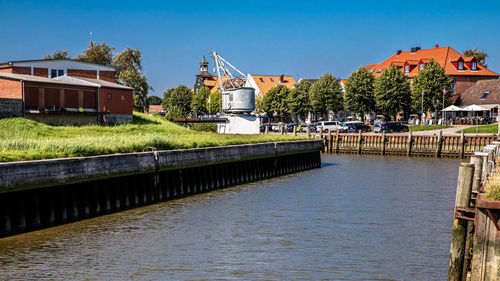 River by buildings against clear sky