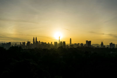 Buildings in city against sky during sunset