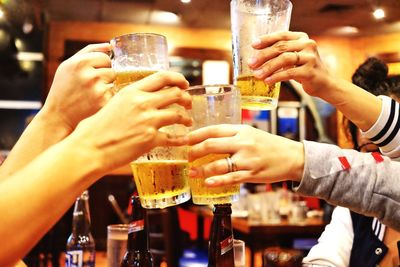 Midsection of man drinking beer in glass