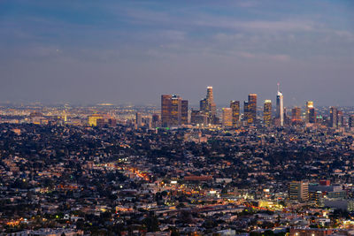 Aerial view of illuminated buildings in city against sky