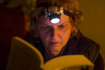 Close-up of senior woman reading book at home