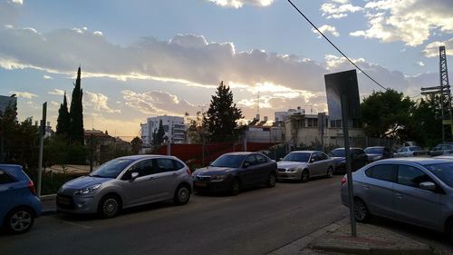 Cars on road against sky in city