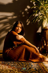 Portrait of young woman sitting at home