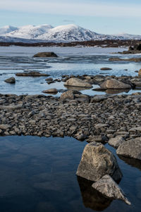 Close-up of rocks in sea against sky