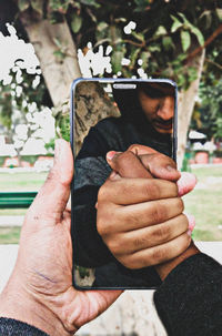 Close-up of man photographing with mobile phone