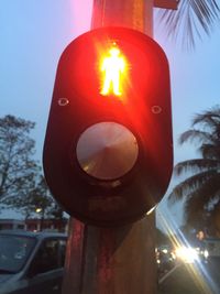 Close-up of illuminated road sign against sky