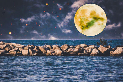 Scenic view of rocks on sea against sky