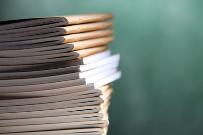 Stack of books at classroom against blackboard