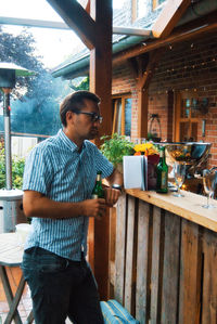 Man standing by glass of restaurant