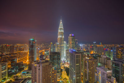 Illuminated modern cityscape against sky at dusk