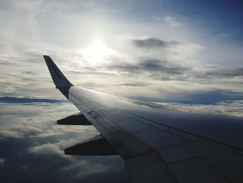 Airplane flying over clouds in sky