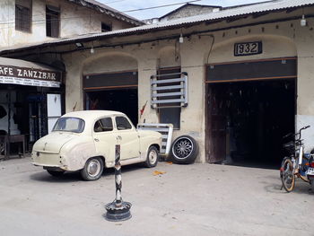 Vintage car parked on street against buildings in city
