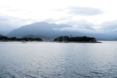 Scenic view of sea and mountains against sky