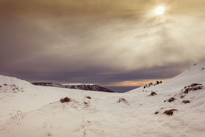 Scenic view of snow covered mountains against sky during sunset