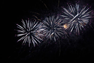 Low angle view of fireworks in sky at night