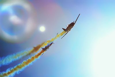 Low angle view of airplane emitting vapor trail against sky