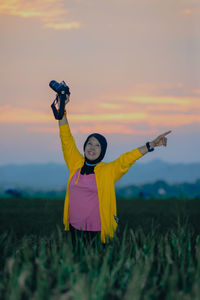 Rear view of woman standing on field