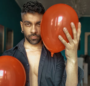 Portrait of man holding balloons