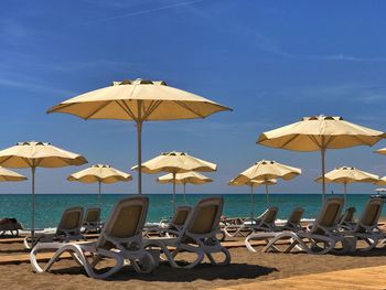 Umbrellas on beach against clear blue sky