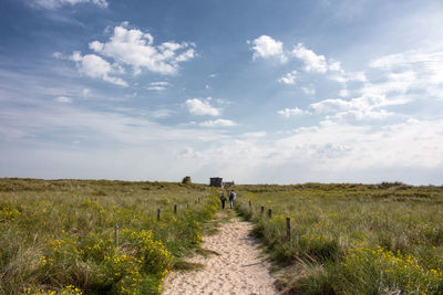 Scenic view of grassy field against cloudy sky