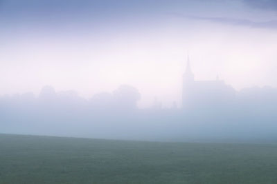 View of buildings against sky in foggy weather
