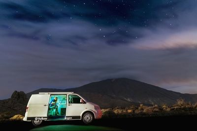 Car against mountain range at night