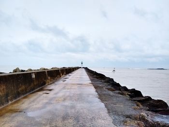 View of groyne in sea against sky