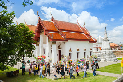 Group of people in traditional building against sky