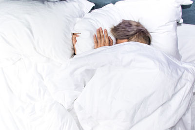 Cropped image of woman sleeping on bed