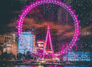 Illuminated ferris wheel at night