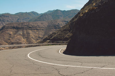 Road by mountain against sky