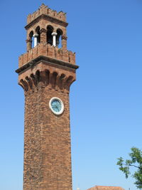 Low angle view of clock tower against blue sky