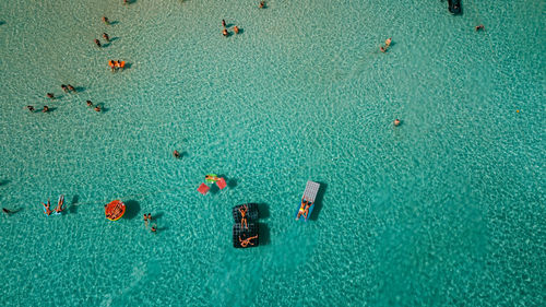 Aerial view of people resting in sea during summer