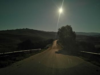 Road leading towards mountains against sky