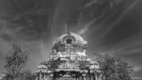 Low angle view of ferris wheel against cloudy sky