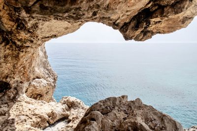 Rock formations by sea against sky