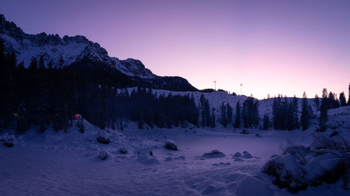 Scenic view of snow covered field against sky during sunset