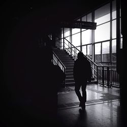 Rear view of man walking at railroad station