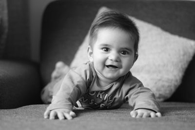 Portrait of cute baby boy lying on sofa