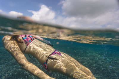 Midsection of woman in bikini snorkeling undersea