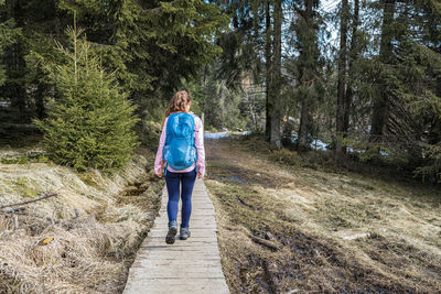 Young happy woman walking in spring snow, hiking alone. the concept of freedom and active lifestyle