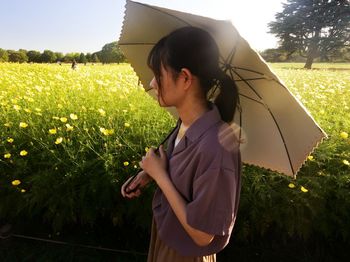 Side view of young woman standing on field