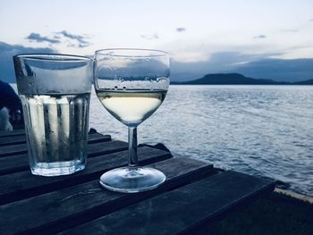 Close-up of wine glass on table against lake balaton