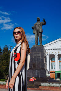 Fashionable young woman standing in city during sunny day
