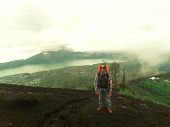 Full length of man standing on mountain against sky